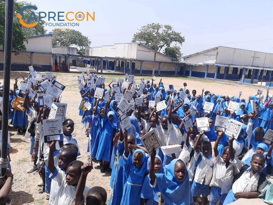 Caprecon outreach with school children holding learning materials